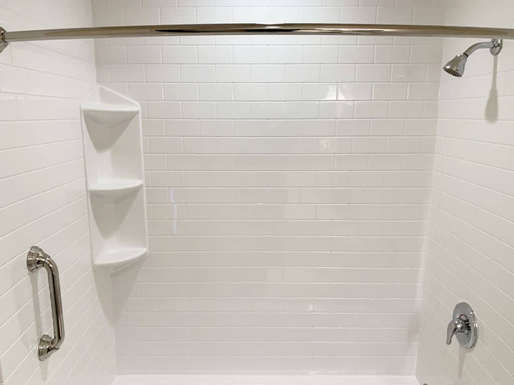 Classic, simple bathroom aesthetic: A white, subway tile pattern surrounding bathtub and shower section. 