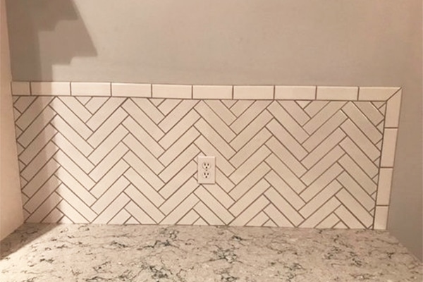 Bathroom Remodeling - DIY herringbone tile but the trim of this backsplash is uneven.