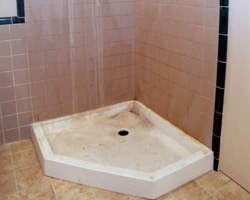 Reason to remodel bathroom - this shower pan and walls are covered in water build up, mold and mildew. 