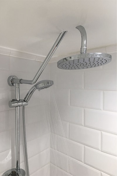 A DIY shower head installation. This shower head is too large so the installer cut holes through the roof to make it fit. 