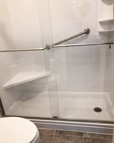 A corner shower seat built into the shower walls. 