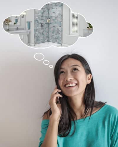 Photo is of a woman on the phone with her eye gazing upwards. Above her head is a thought cloud with the picture of a remodeled bathroom within it. 