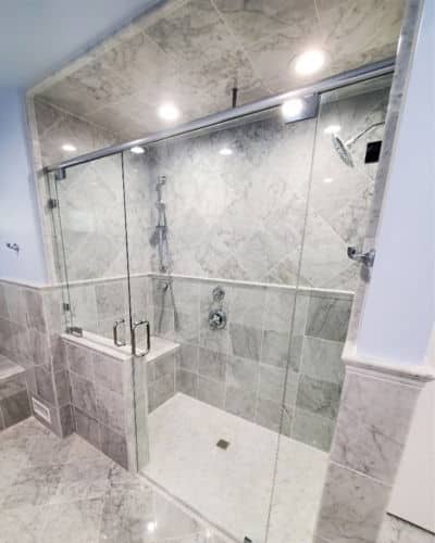 low and no threshold. Shower - Master Walk-in Shower with no threshold. Shower is tiled with grey walls and floor and is enclosed with a glass door.