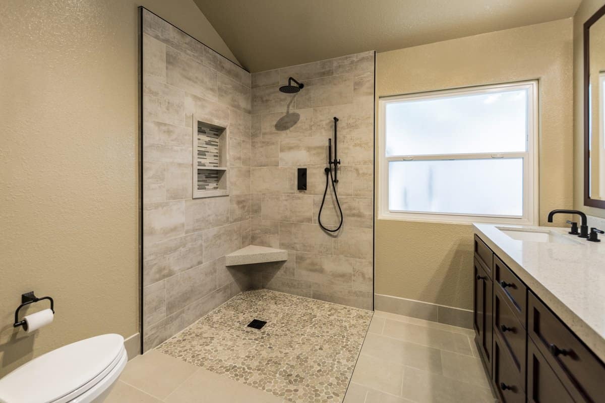No threshold walk-in shower with an open floor plan. shower area is designated by its unique tiled floor pattern.
