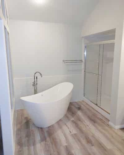 TYPES OF BATHTUBS: Pictured is a white, slipper, stand alone tube, set across from a walk-in shower.