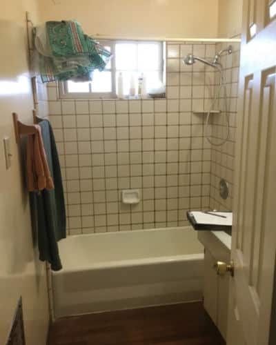 8 Before and After Bathroom Remodel Photos: A Shower + tub comb bathroom with square tiles covering the wet wall area. Tiles are dirty and old.