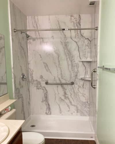 8 Before and After Bathroom Remodel Photos : the tube area was transformed into a low-threshold walk-in shower, with marble wall surround.