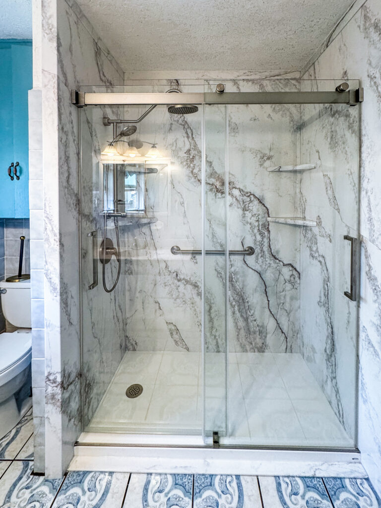 Small master bathroom remodel featuring premium composite walls and bypass barn doors